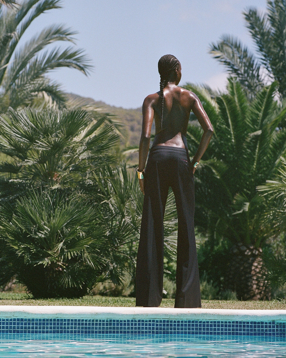 serena bute london trouser studio mid rise flare wool trouser worn on girl next to pool in ibiza